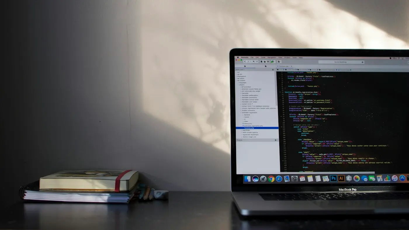 A laptop with code open on a quiet desk in evening light.