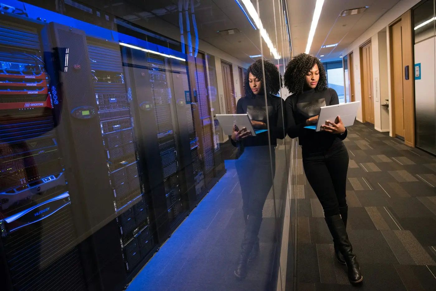 An engineer with a laptop in a server room.